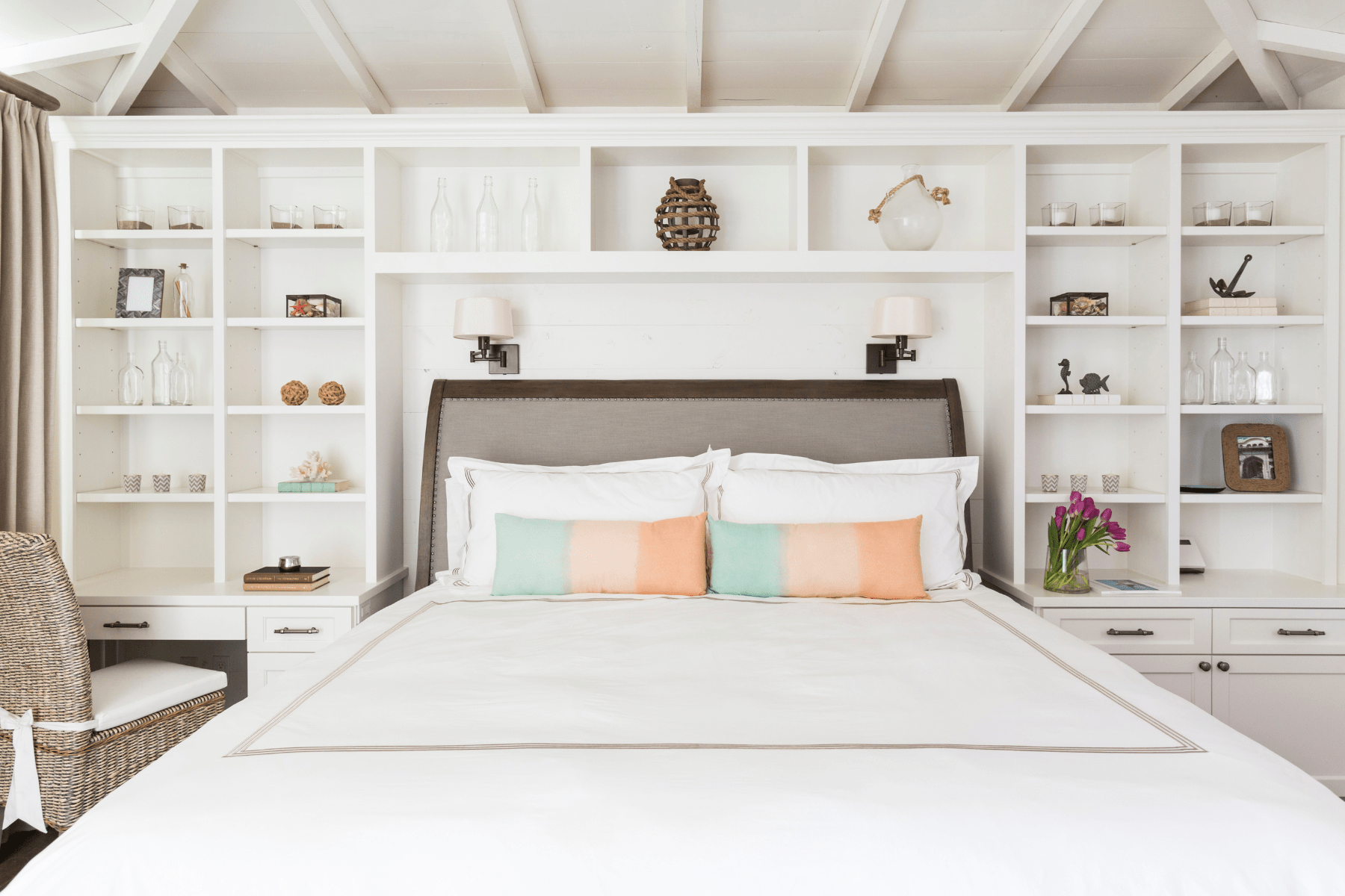 The Sandhill Shores master bedroom featuring bright peach and soft blue colors below a sloped ceiling with wooden beams.