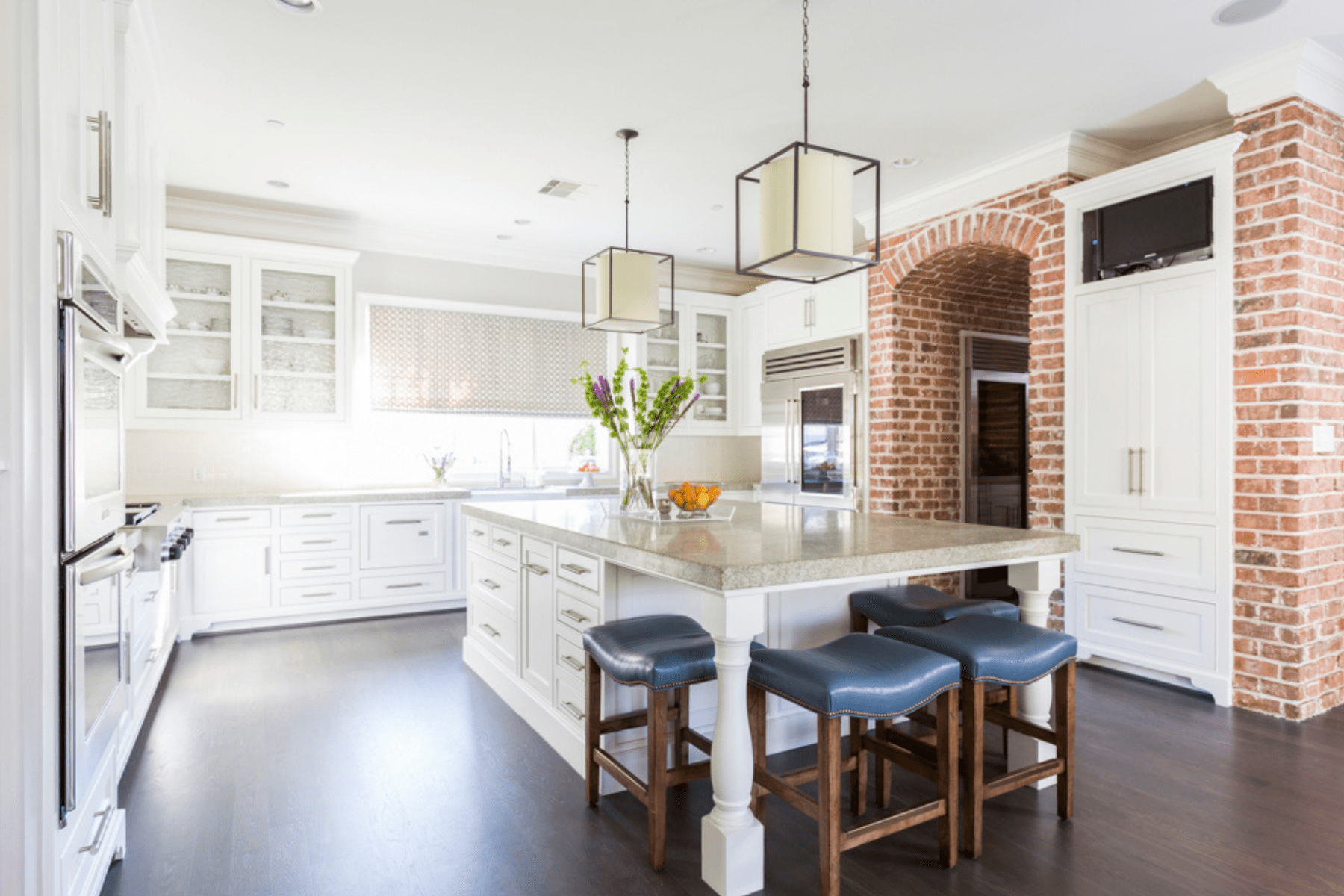 The Creekside kitchen featuring geometric light fixtures and elegant, white cabinetry.