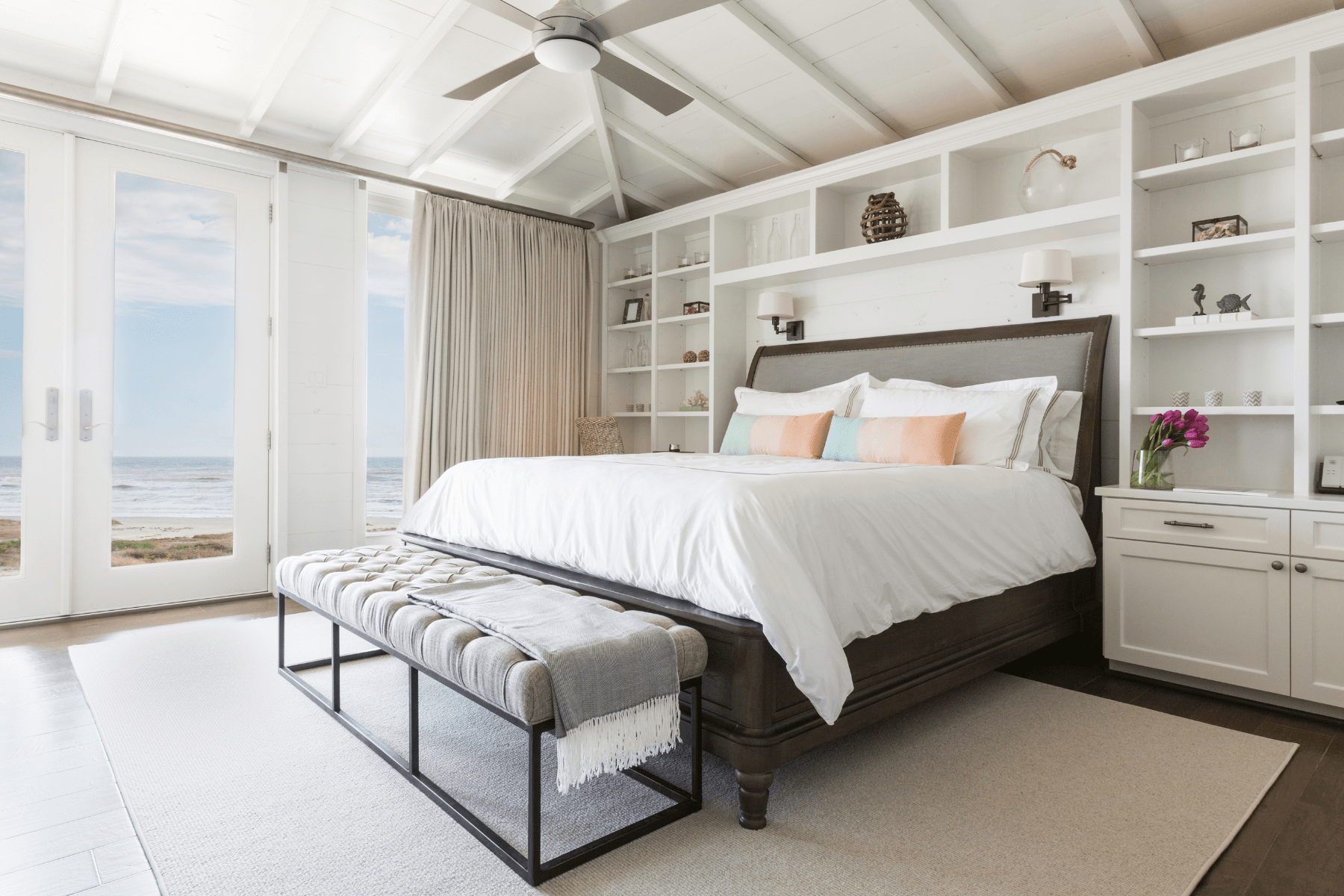 A view of the Sandhill Shores master bedroom with custom white built-in shelving and a soft palette for a coastal feel.