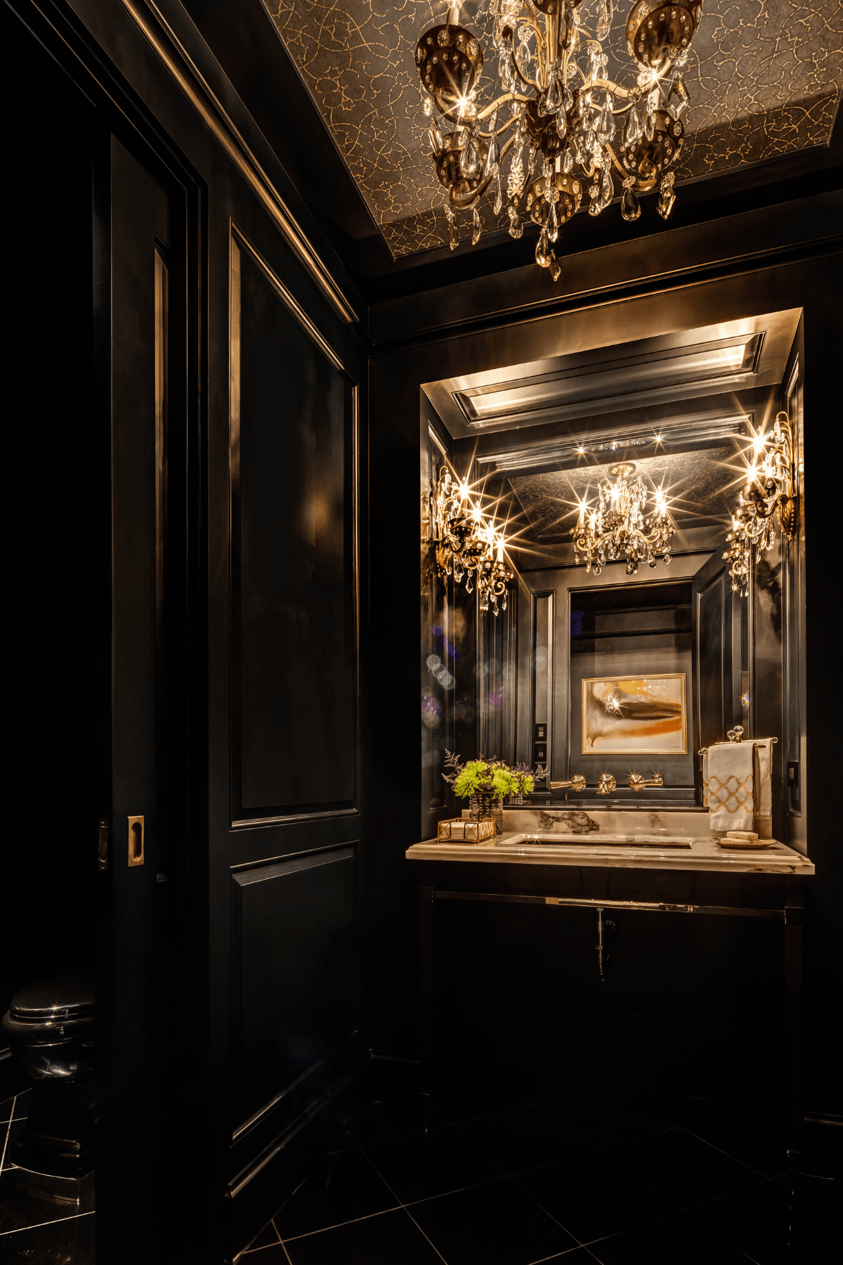 A powder room at the Willowick Residence. Its dark walls, chandelier, and customized ceiling call for an elegant ambiance.