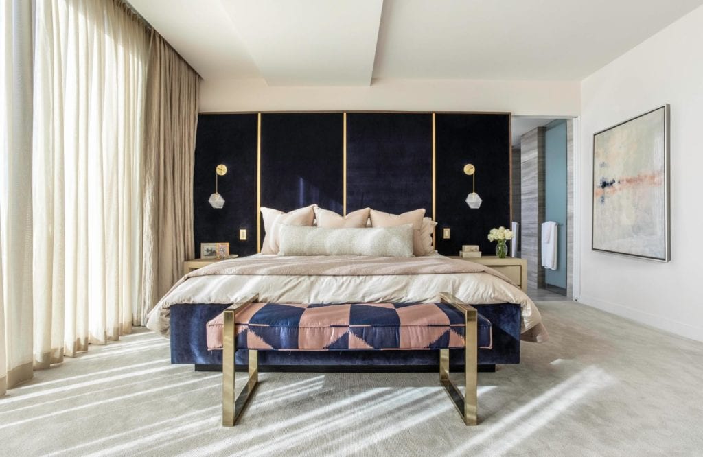 A beautiful bedroom with perfect light fixtures and a stunning headboard