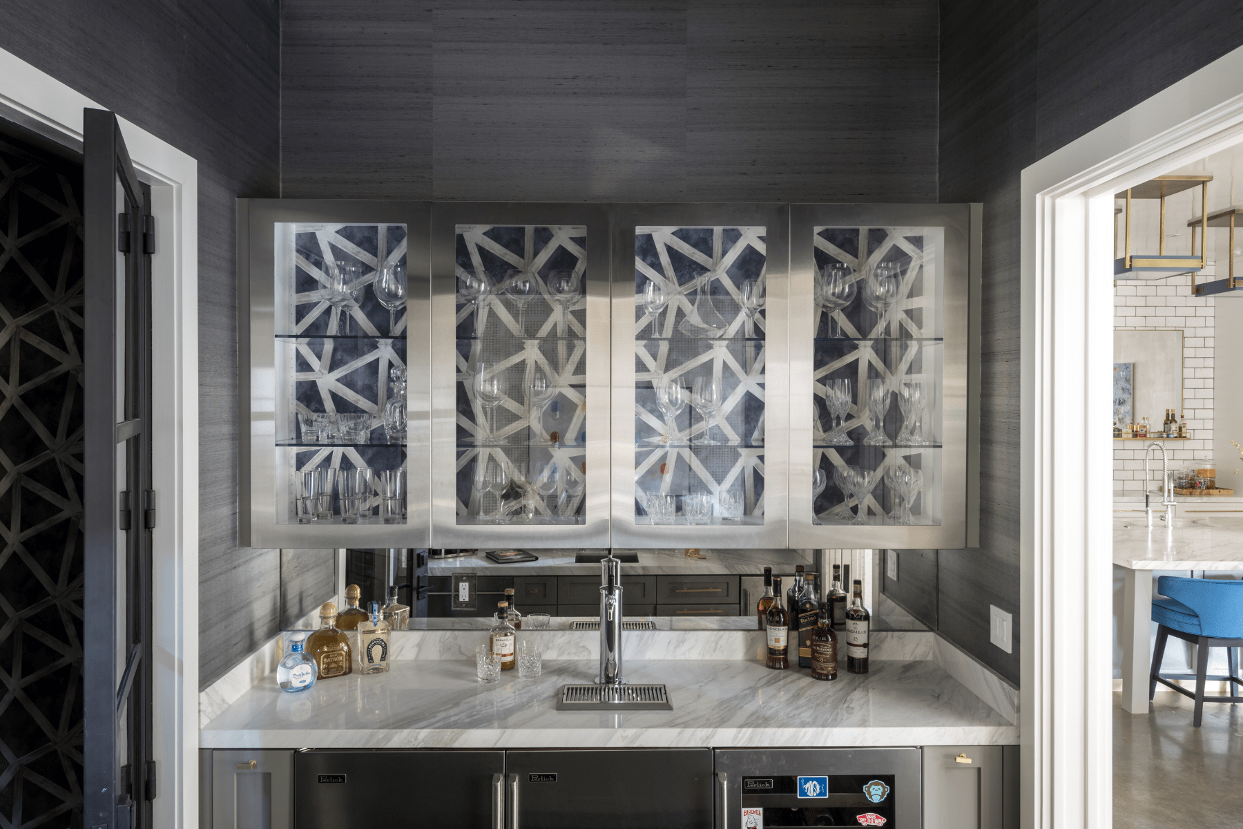 The luxurious Drexel bar featuring a marble countertop and bold wallpaper in the cabinetry.
