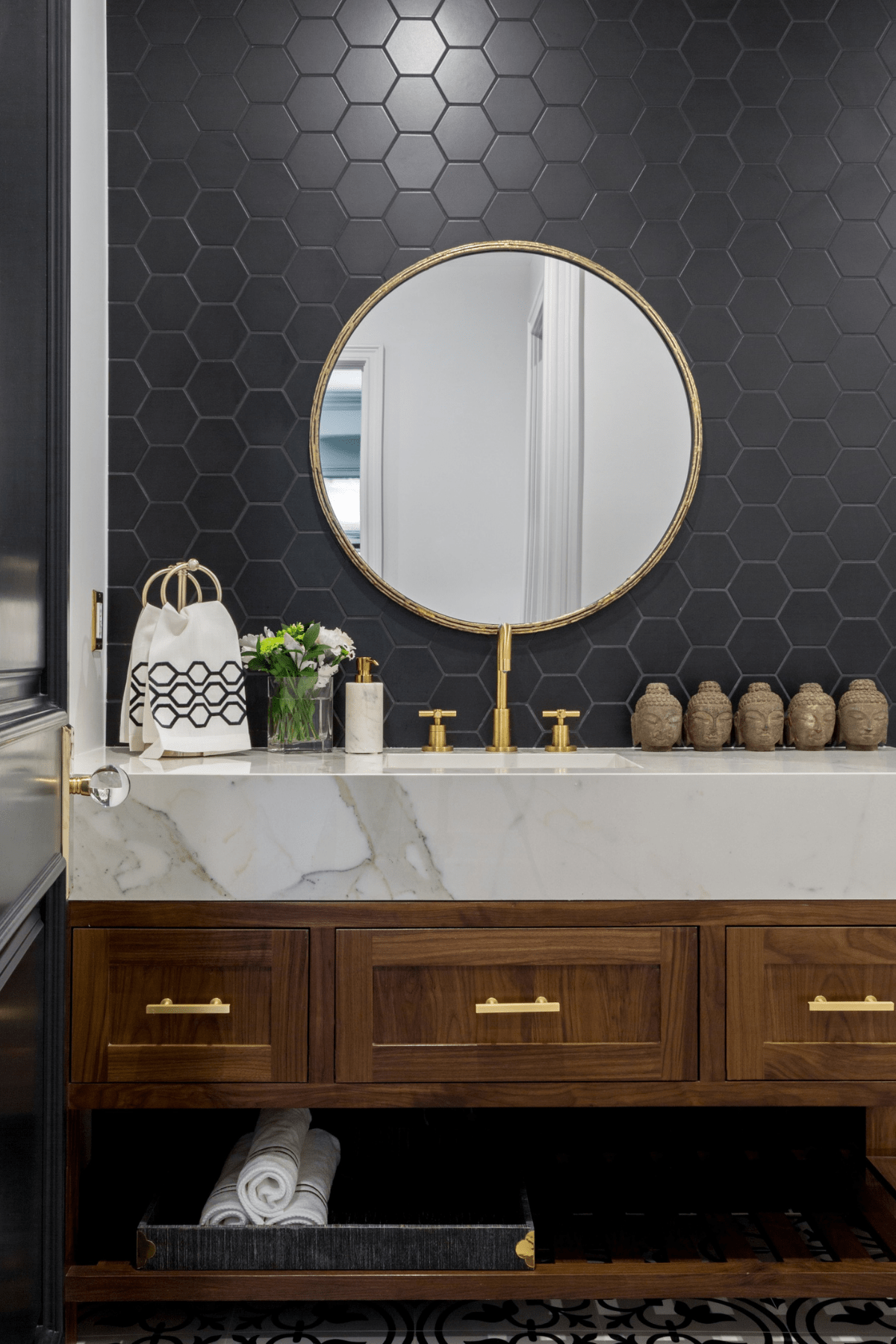 A marble top counter and wooden cabinetry against honeycomb wallpaper in the Encino bathroom.