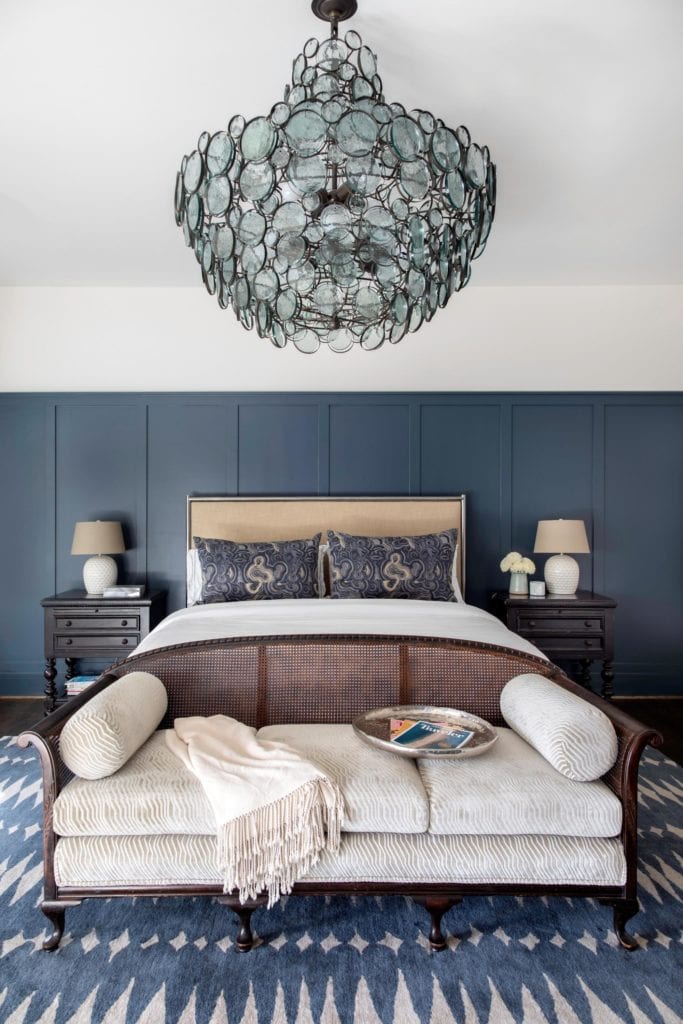 A dramatic statement lighting fixture adds the perfect touch to this beautiful bedroom 