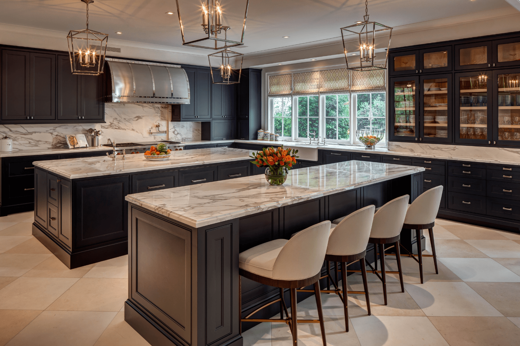The Willowick kitchen featuring marble counter tops paired with chic stools and lighting fixtures.