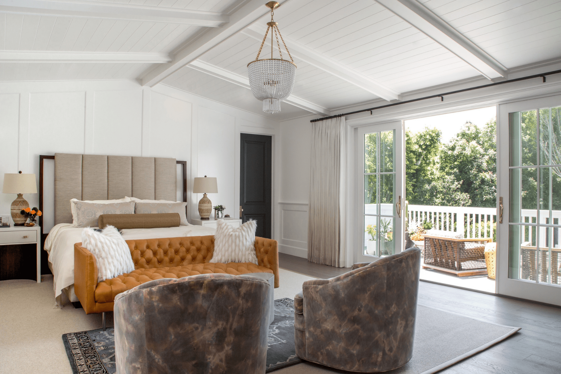 A California-Moroccan Glam style bedroom with sloped ceilings and reupholstered furnishings.