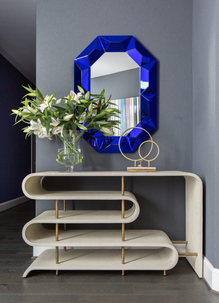 A hallway at a condo in the Astoria high rise with blue mirror and lillies