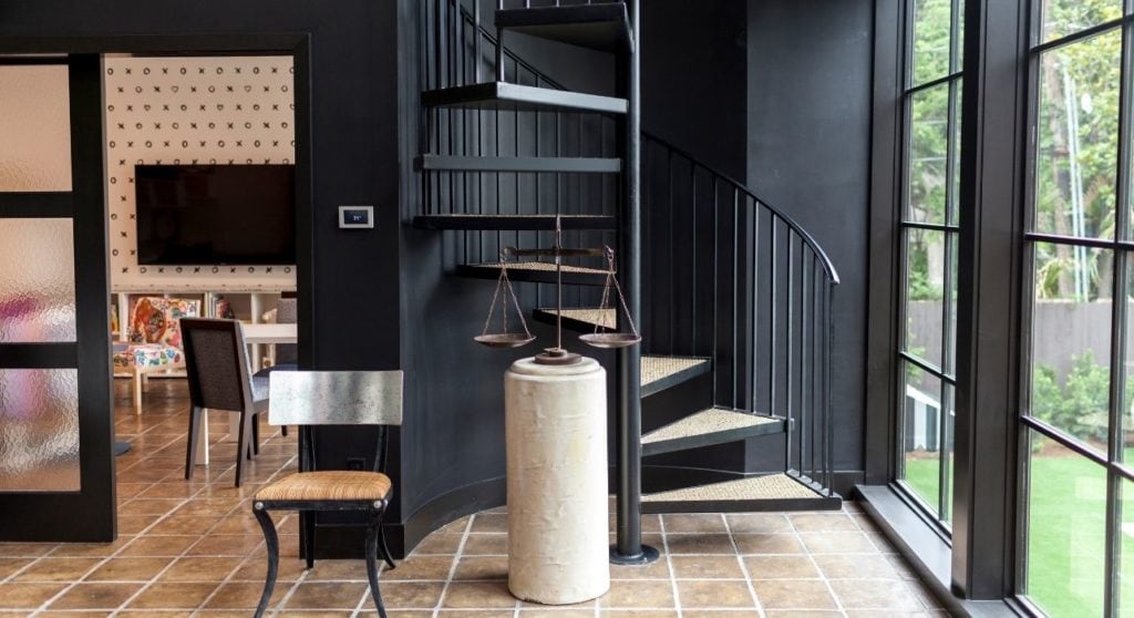 A black iron staircase camouflages itself against black walls in this spacious family area