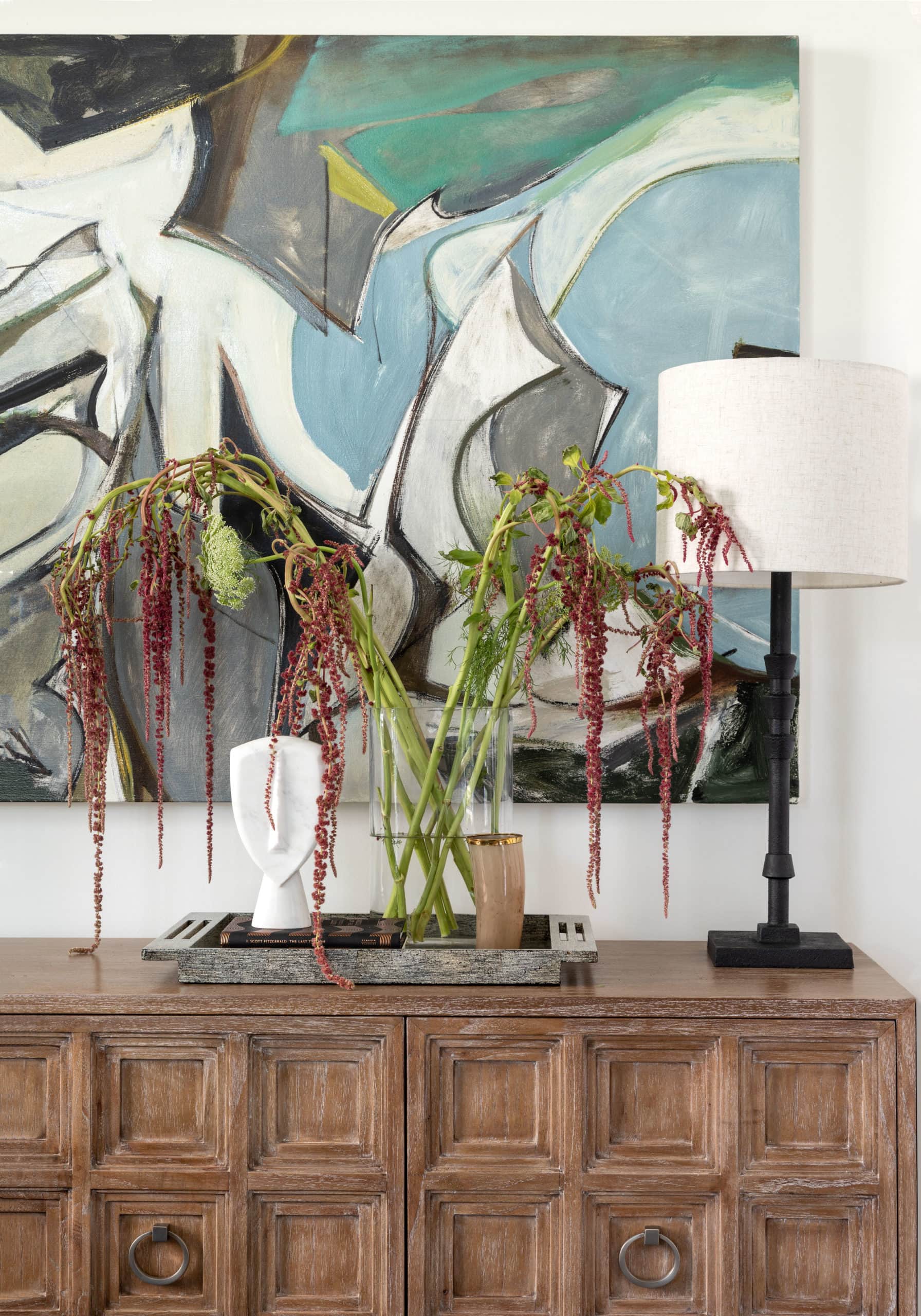 A close up detail of a rustic console and modern art piece at a Houston home, designed by Laura U