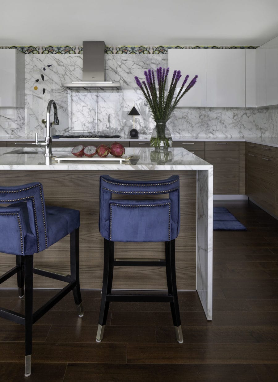 Modern high-rise kitchen with blue velvet stools and Poggenpohl cabinetry
