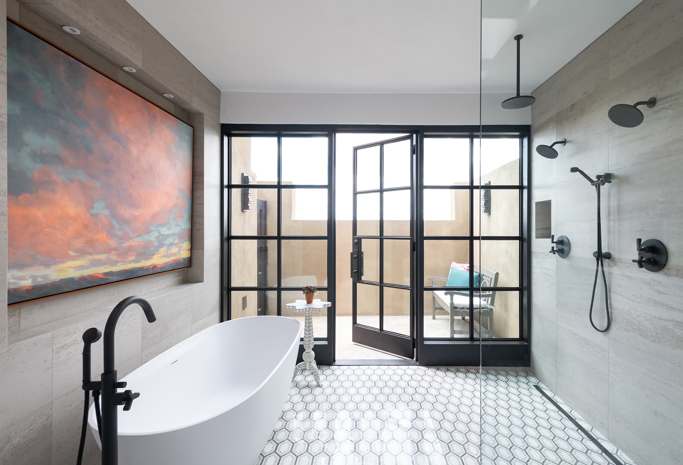 A vibrant sky painting and tons of natural light bring the beauty of the outdoors into this primary bath oasis
