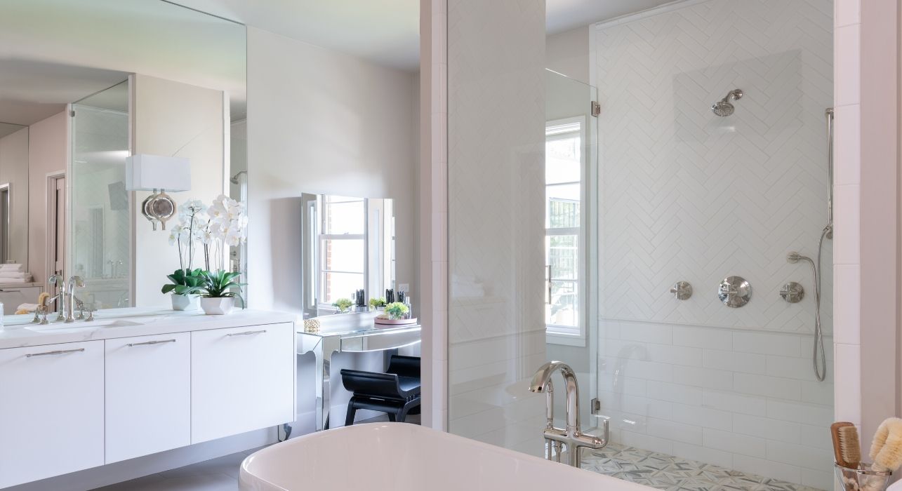 White bathroom with Kohler faucets and soaker tub in the North master bathroom designed by Laura U