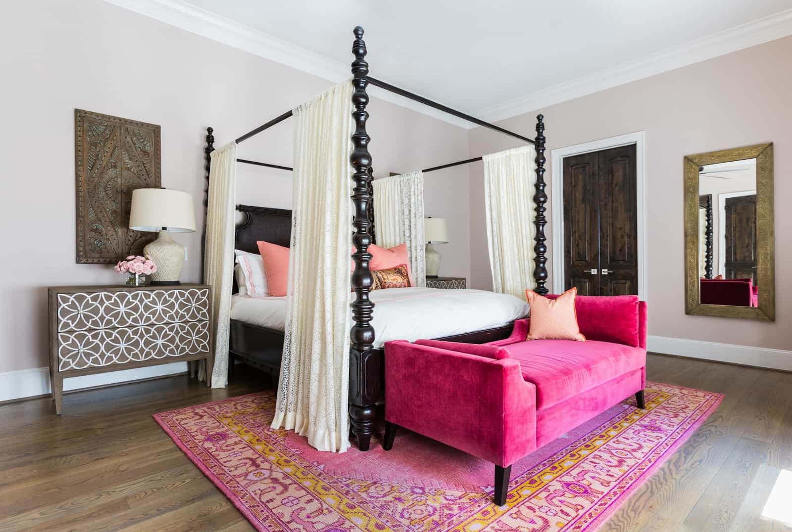 Master bedroom with deep pink velvet chaise lounge designed by Laura U
