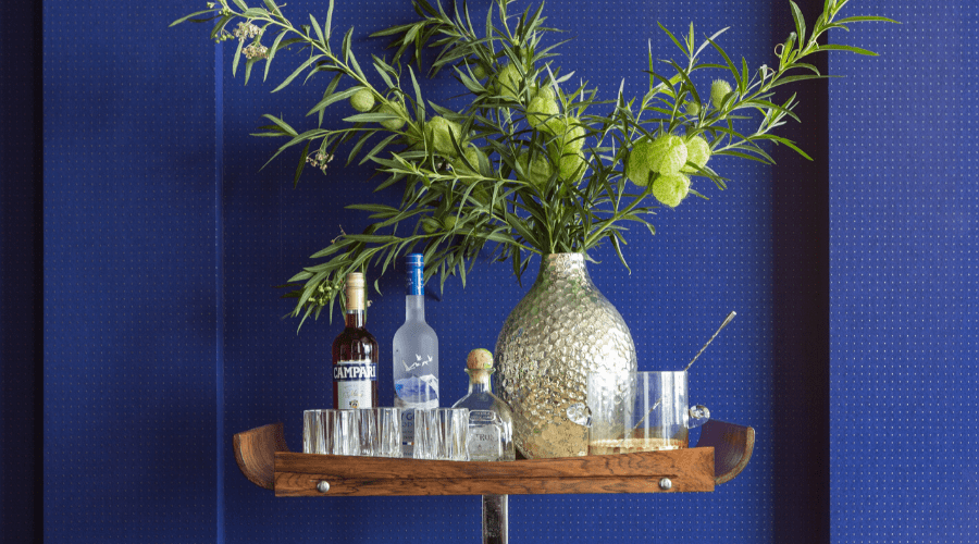 A wood bar cart from 1stdibs constrasts against a cobalt blue Arte wall covering.