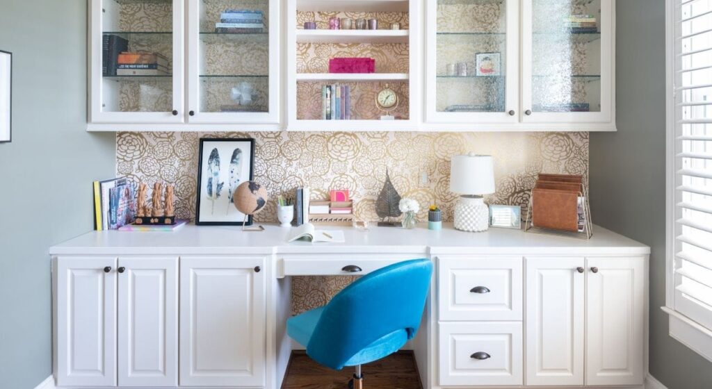 A stylish home office with termporary wall covering and glass cabinets by Laura U