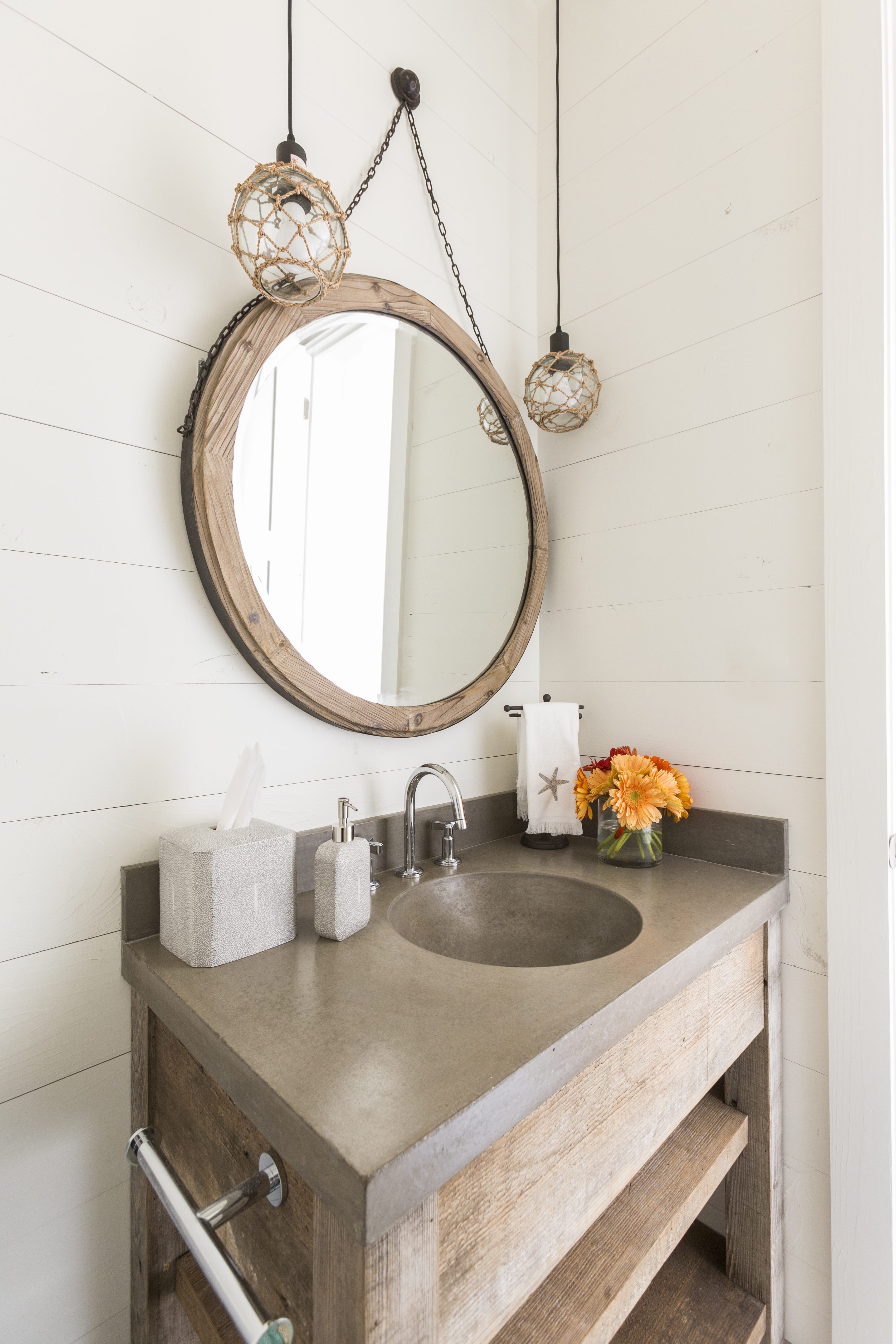 Wooden round hanging mirror placed in a natural bathroom