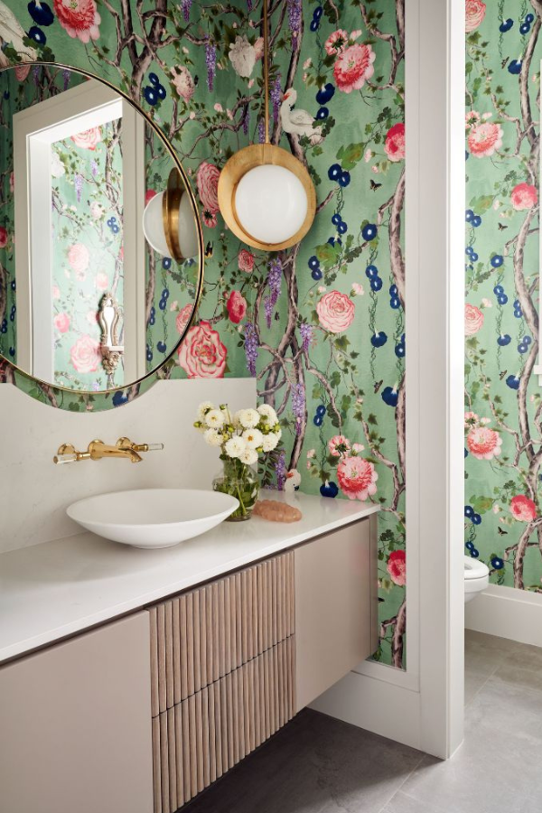 luxurious green accents in a floral wallpaper in a bold powder room