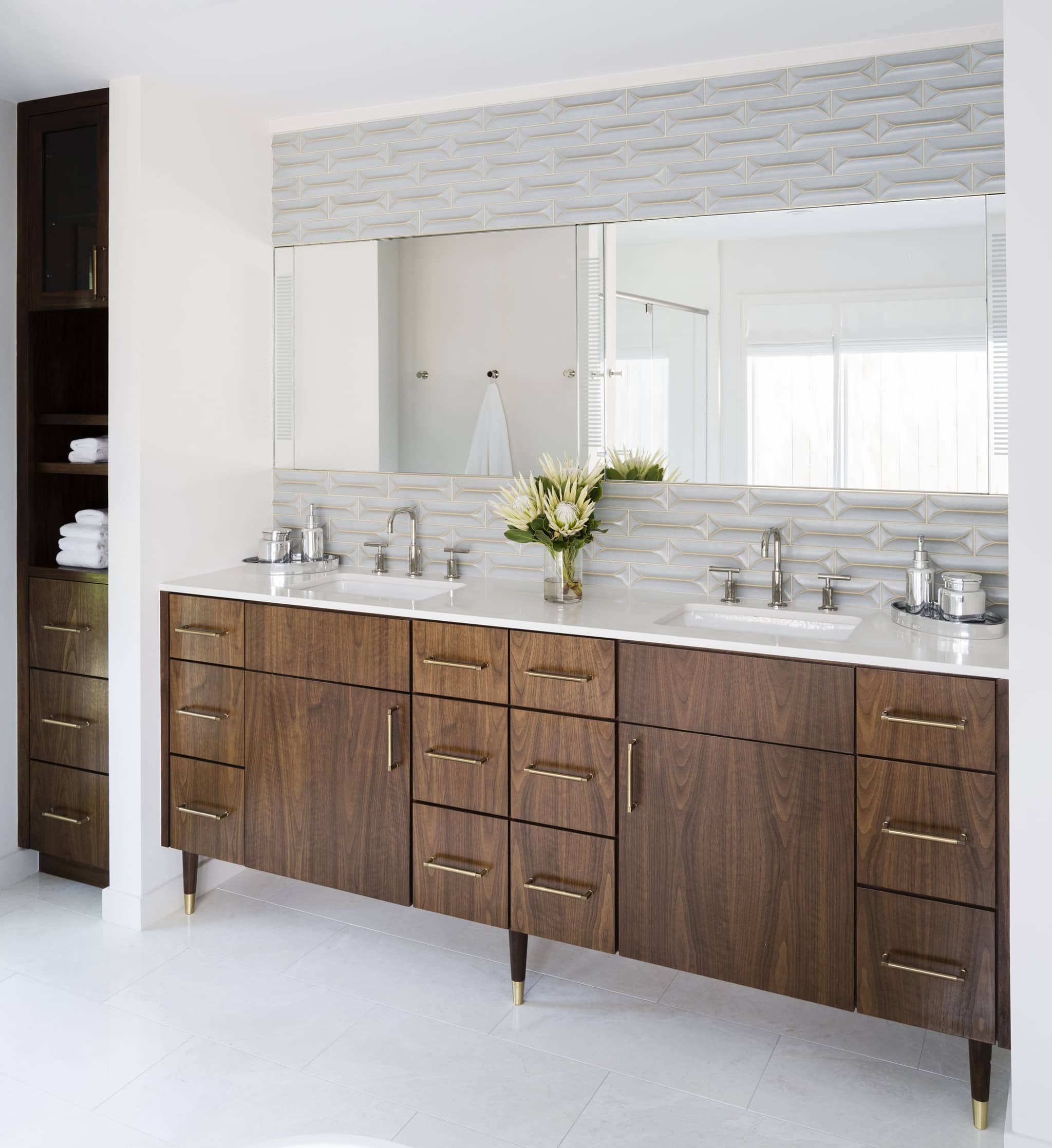 Designed by Laura U, this master bathroom features Ann Sacks tile and warm woods.